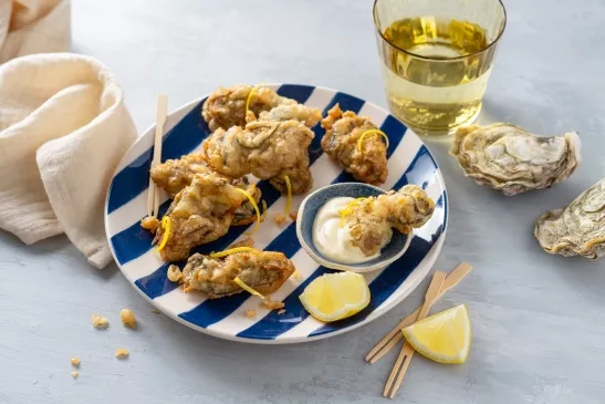 Assiettes avec des huîtres panées et une mayonnaise citronné