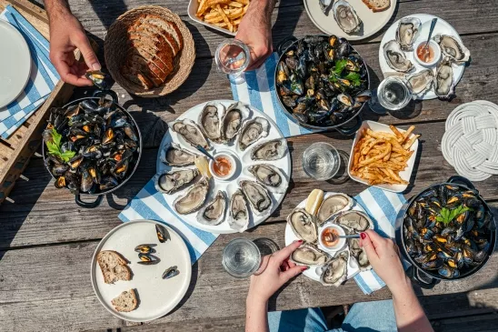 Deux personnes dégustent des huîtres et des moules dans une cabane de dégustation sur l'île de Noirmoutier.